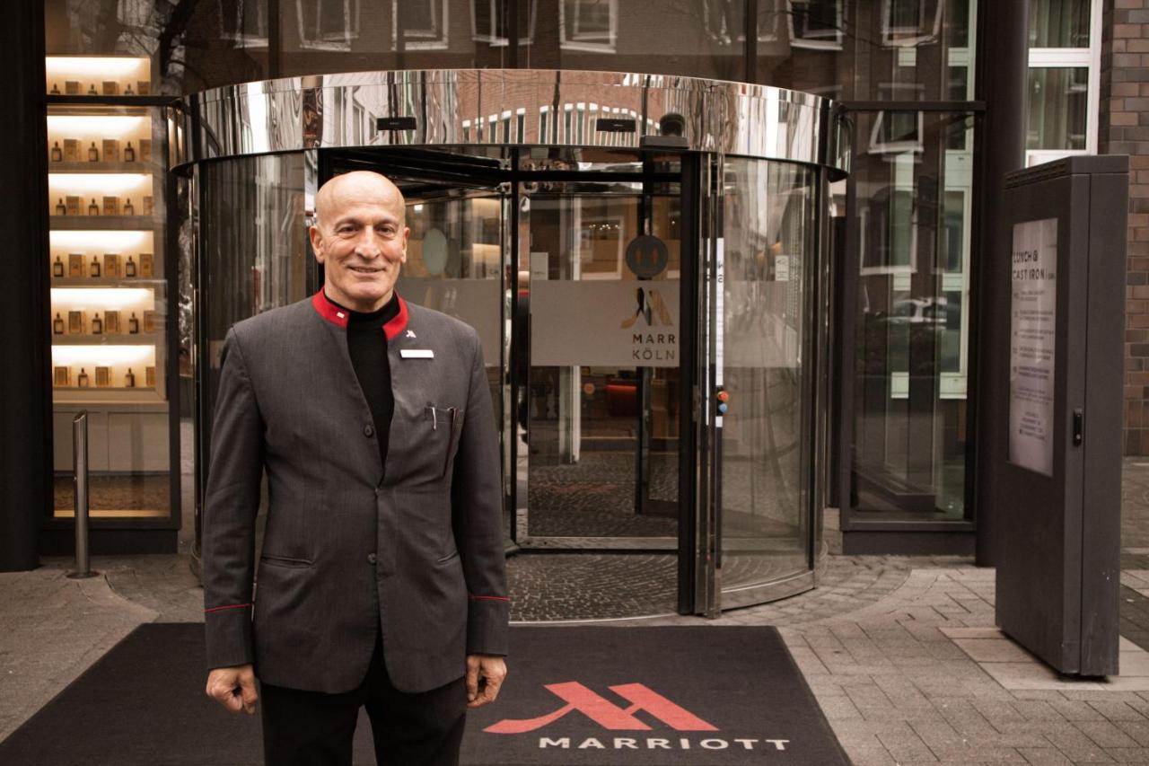 Cologne Marriott Hotel Bagian luar foto A doorman at the entrance of a hotel