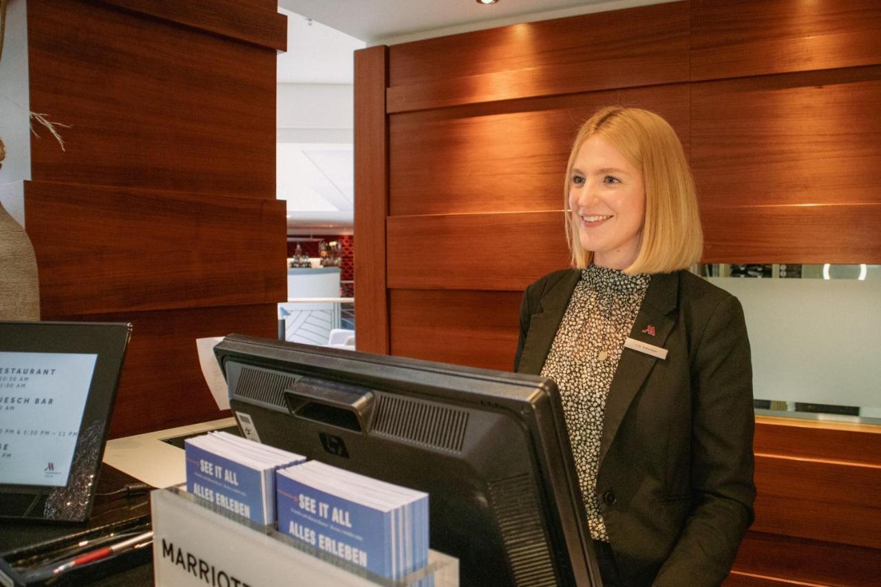 Cologne Marriott Hotel Bagian luar foto A hotel receptionist