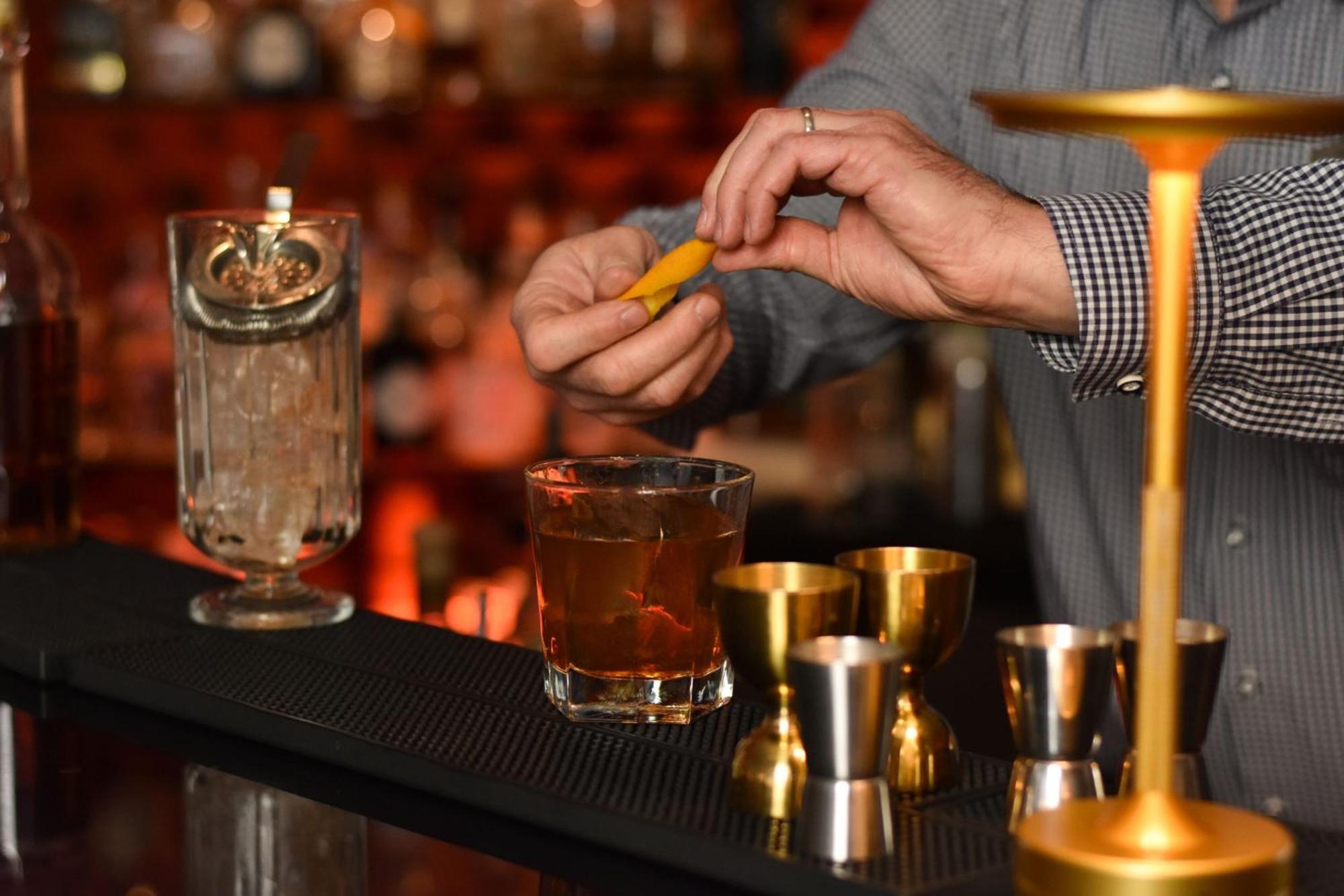 Cologne Marriott Hotel Bagian luar foto A bartender adding a lemon twist to a cocktail